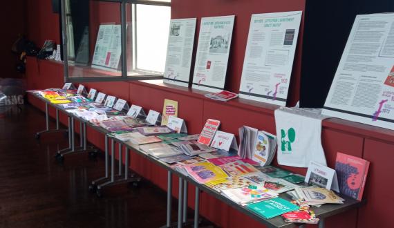 Photo représentant une table de presse du PF69, avec des brochures thématiques et notre exposition sur l'IVG affichée au mur