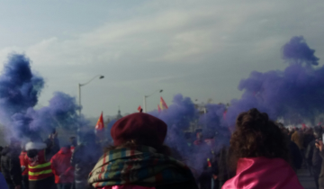 Fumigène violet au-dessus du cortège féministe