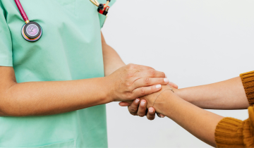 Personnel de santé qui prend la main d'un·e patient·e