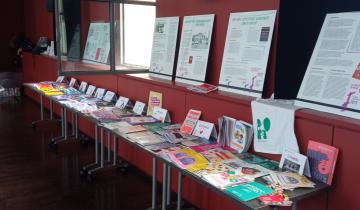Photo représentant une table de presse du PF69, avec des brochures thématiques et notre exposition sur l'IVG affichée au mur